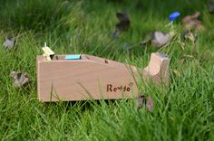 a wooden toy boat sitting in the grass