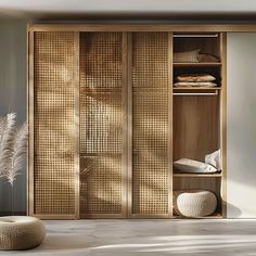 an open wooden closet with white pillows on the floor and plants in vases next to it