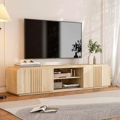 a flat screen tv sitting on top of a wooden entertainment center in a living room