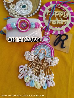 some beads and other items are laying on a yellow table cloth with a happy birthday sign in the background