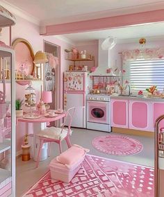 a pink kitchen with lots of furniture and decor