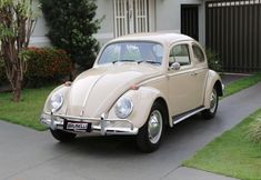 an old vw bug parked in front of a house