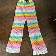 a pair of colorful crocheted pants sitting on top of a wooden floor