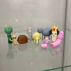 a group of toy animals sitting on top of a glass table next to each other