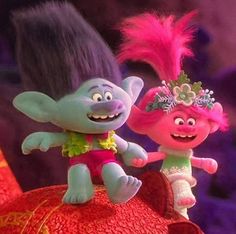 two cartoon characters are standing on top of a red object with pink hair and green eyes