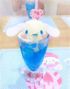 an ice cream sundae with blue liquid in a glass on top of a table