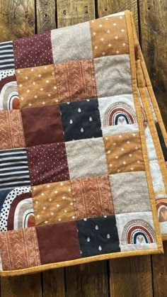 two quilted placemats sitting on top of a wooden table next to each other