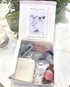 an open box containing personal care items on a table with flowers in the back ground