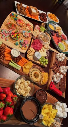 a table filled with different types of snacks and desserts on trays next to each other