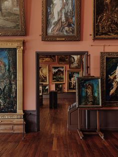 an art gallery with paintings on the wall and wooden flooring in front of it