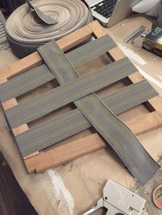 a wooden cross sitting on top of a table next to a laptop and other items