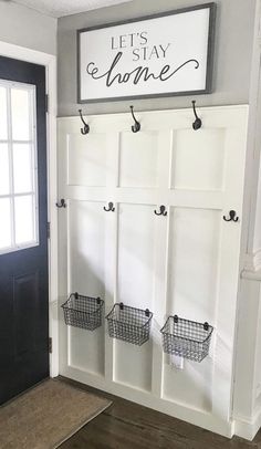 the entryway is decorated in white and black with baskets hanging from it's hooks