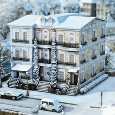 a model of a building with cars parked in front of it and snow on the ground