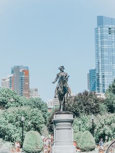 a statue of a man riding on the back of a horse in a city park