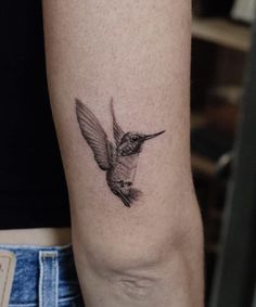 a small hummingbird tattoo on the arm