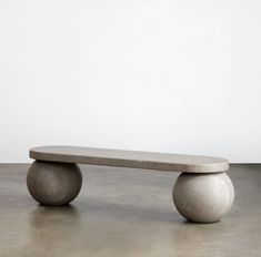 a concrete bench sitting on top of a cement floor in front of a white wall