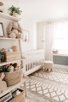 a baby's room with a crib, bookshelf and stuffed animals