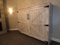 a large wooden cabinet sitting in the corner of a living room next to a fireplace