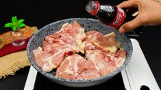 a person is pouring ketchup on raw meat in a bowl