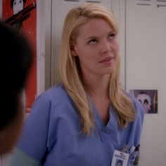 a woman in scrubs standing next to a man