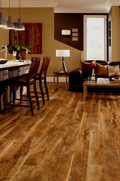 a living room filled with furniture and a wooden floor covered in hard wood planks