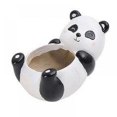 a ceramic panda bear sitting on top of a toilet