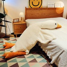 a bed with two pillows on top of it and an animal shaped pillow in the middle