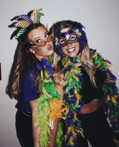 two women in mardi gras costumes posing for the camera