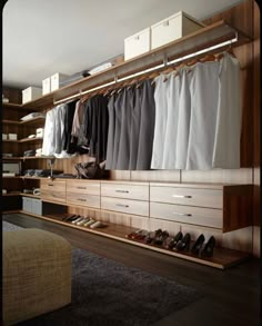 an organized closet with shoes, pants and other items on shelves next to a bed