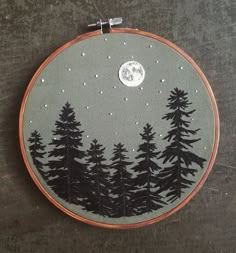 a embroidery project with trees and the moon