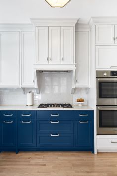 a kitchen with white cabinets and blue drawers