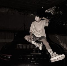 a person sitting on top of a car in the dark