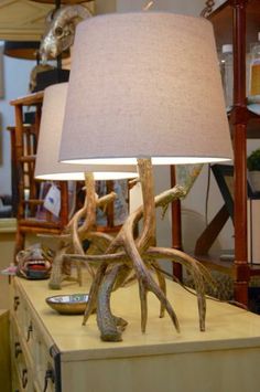 a lamp that is sitting on top of a wooden table with antlers around it