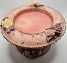 a pink vase with some flowers on it