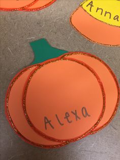 paper pumpkins with name on them are sitting on the floor next to each other