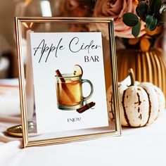 an apple cider bar sign sitting on top of a table next to pumpkins