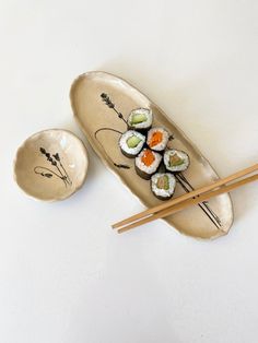 sushi on a plate with chopsticks next to it