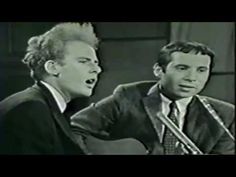 two men are singing into microphones while one man is holding a guitar and the other has his mouth open