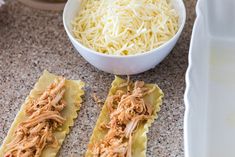 two pieces of ravioli with shredded cheese in a bowl and another dish on the counter