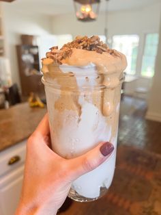 a person holding up a glass with some food in it