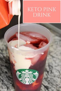 a drink in a plastic cup with ice and strawberries on the rim, next to a sign that says keto pink drink