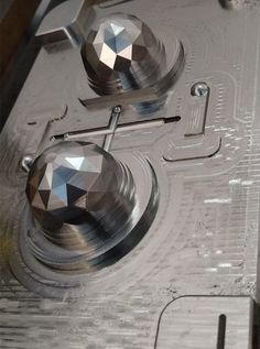 two metal knobs on top of a piece of machinery that looks like it has been cut