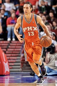 a basketball player dribbling the ball down the court while people watch from the stands