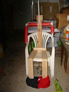 a wooden chair sitting in a room next to a pile of boxes and other items