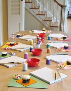 the table is set up with paper, markers, and cupcakes on it