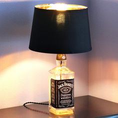 a lamp that is sitting on top of a table next to a bottle with a label on it