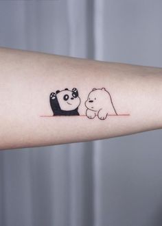 a small panda and bear tattoo on the arm