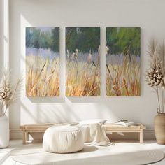 three paintings hanging on the wall in a living room