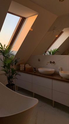 a bathroom with two sinks and a skylight in the ceiling, along with a bathtub