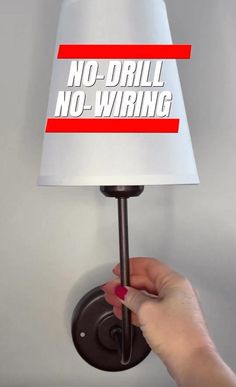 a person holding a lamp with the words no - drill, no - wiring on it